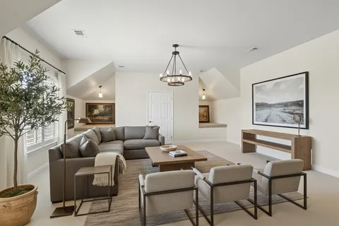 a living room with furniture and a chandelier