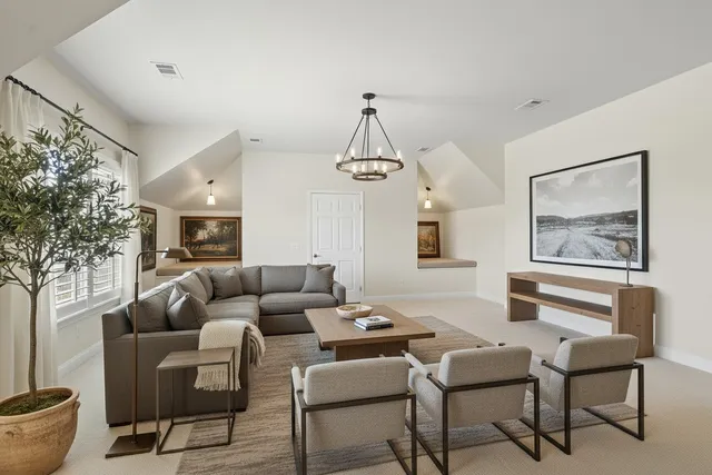 a living room with furniture and a chandelier