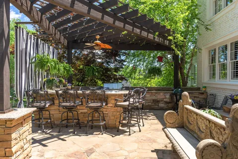 a view of a patio with table and chairs potted plants and large tree