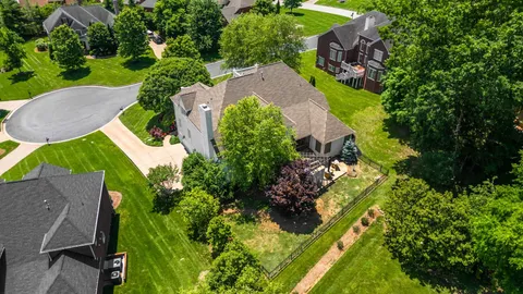 an aerial view of a house with a yard and trees