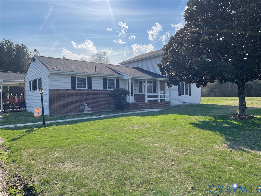 a view of a house with a yard and a large tree