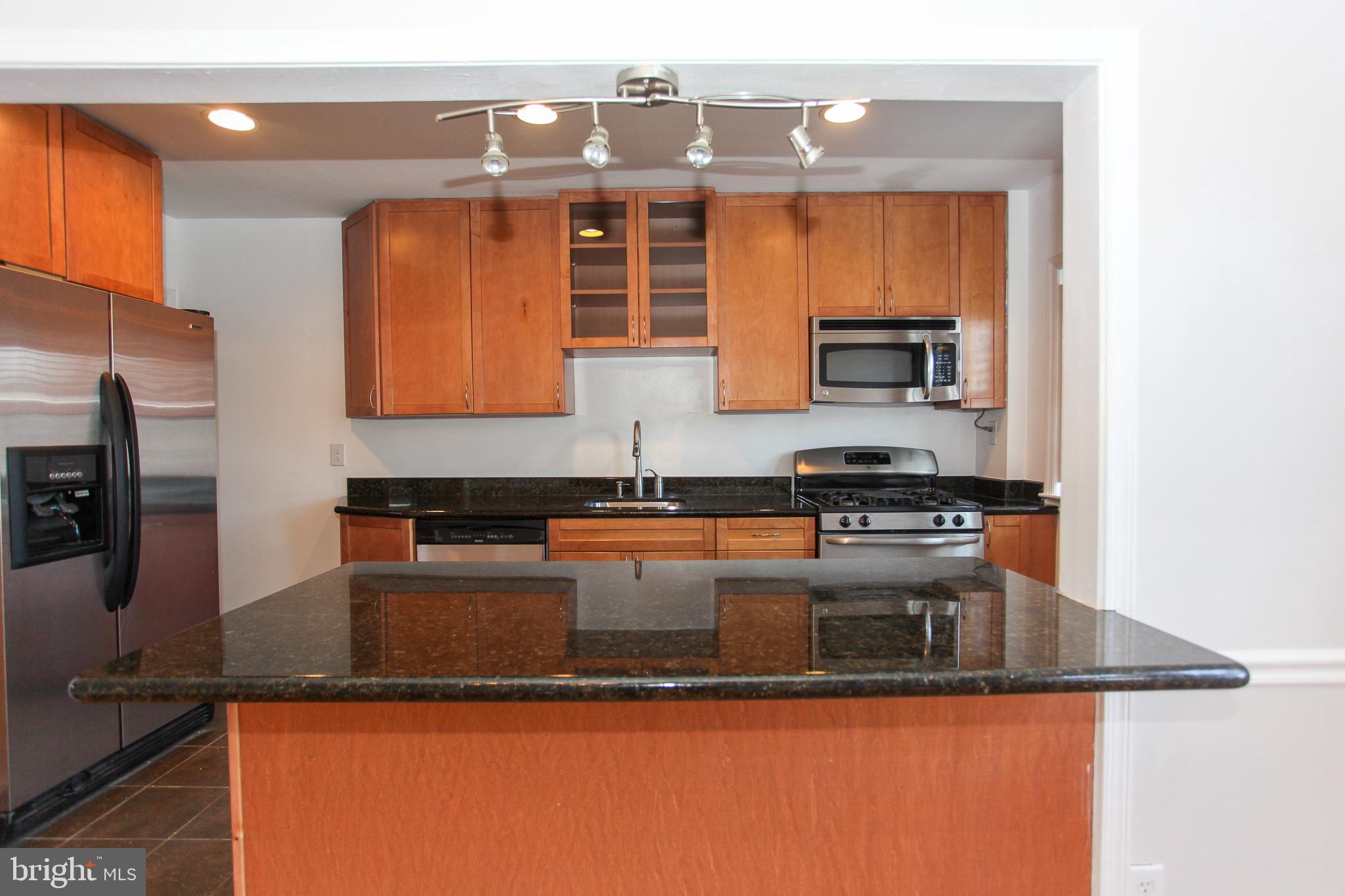 323 Greenlow Road Catonsville, MD 21228 - Photo 9 of 38 a kitchen with granite countertop a sink a stove and a microwave