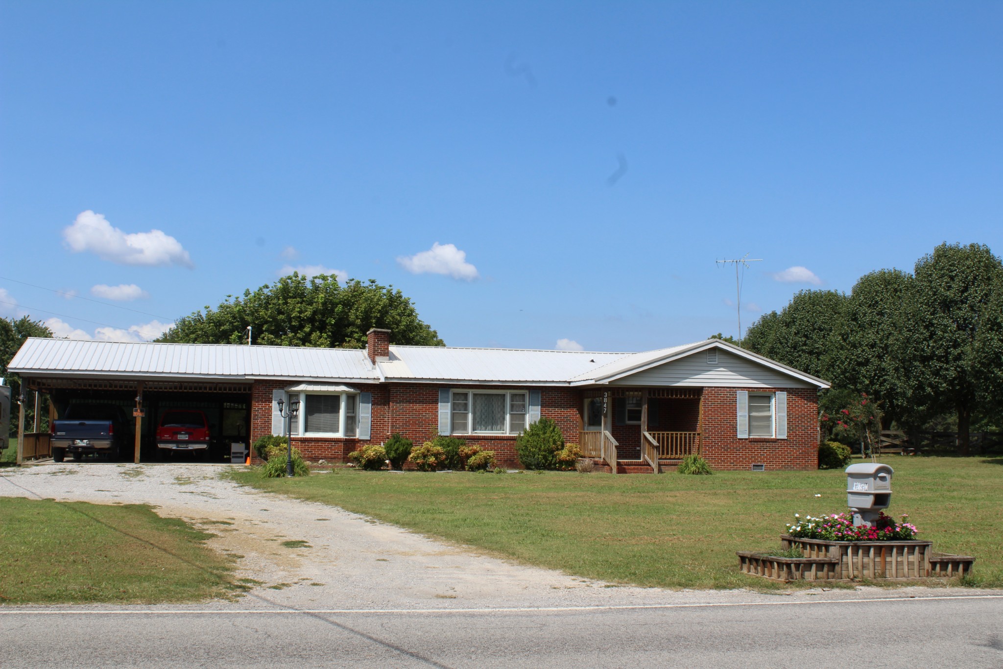 a front view of a house with a yard and trees