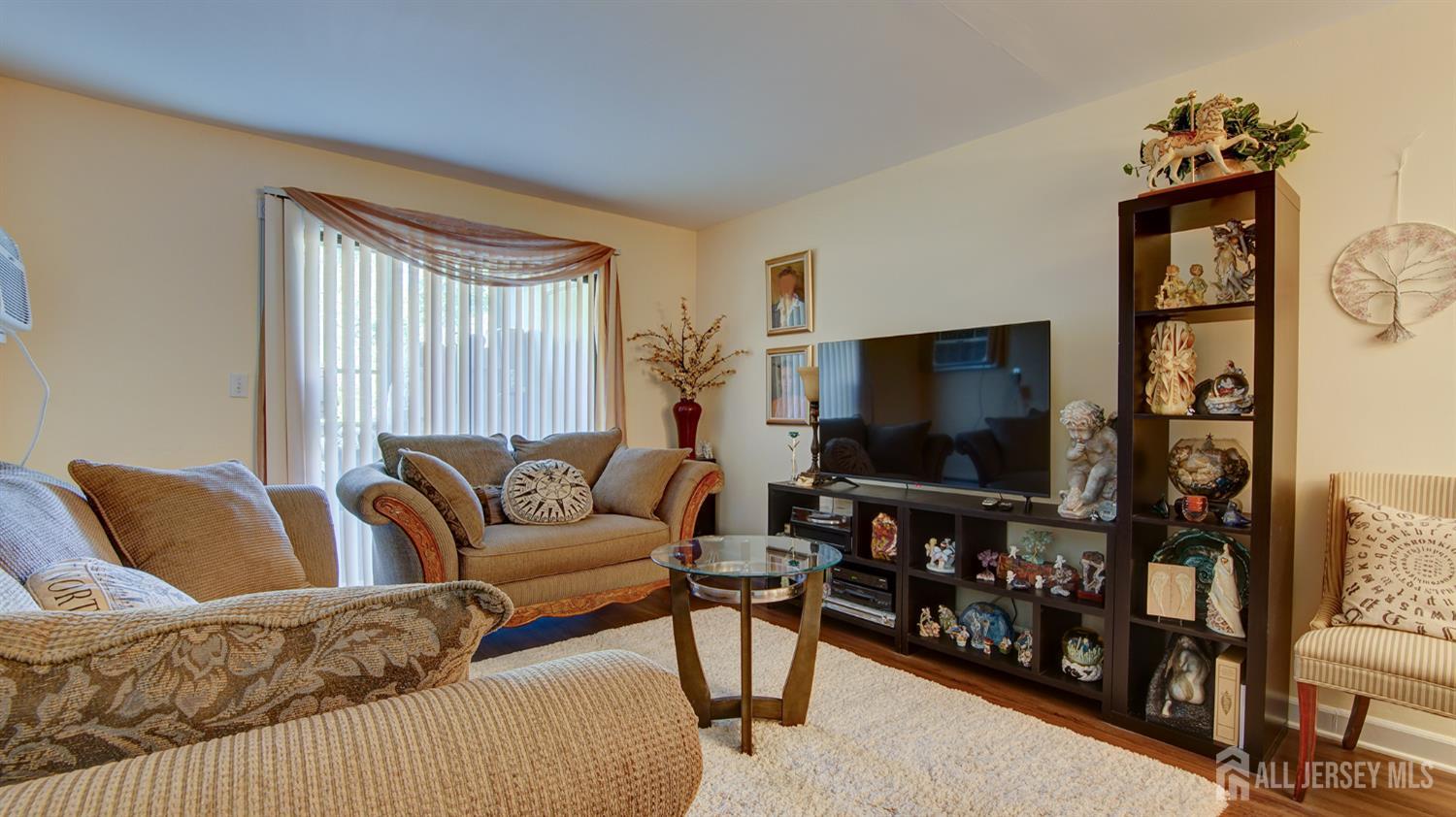 86 Arrowood Road, Unit G Manalapan, NJ 07726 - Photo 3 of 16 a living room with furniture and a flat screen tv