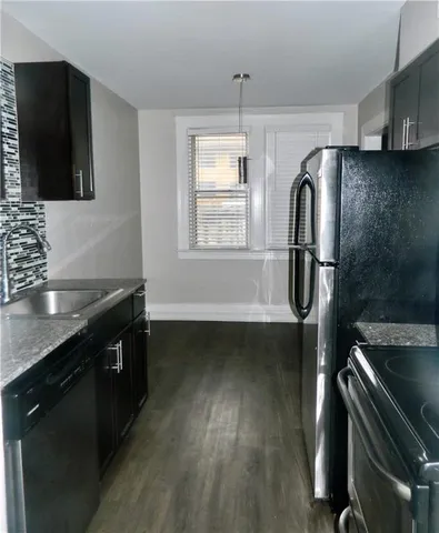 a kitchen with a sink and wooden floor
