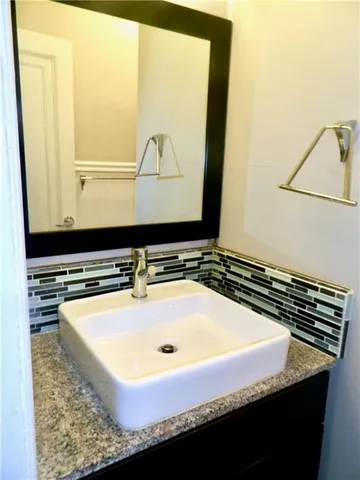 a bathroom with a granite countertop sink and mirror