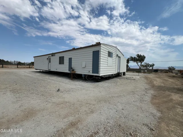 a view of a house with a yard and wooden fence