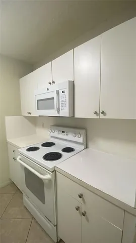 a white stove top oven sitting inside of a kitchen