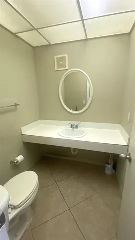 a bathroom with a sink a toilet and a mirror