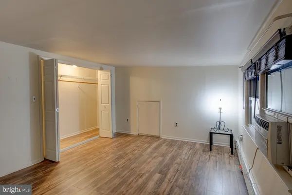 a view of empty room with wooden floor