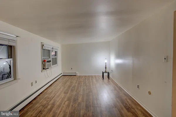 a view of empty room with wooden floor