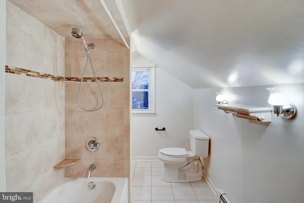 a white toilet sitting next to a bath tub