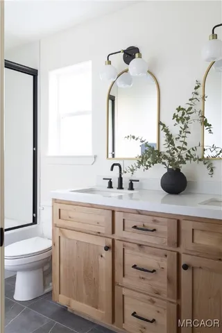 a bathroom with a sink mirror and toilet