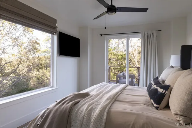 a bedroom with a large bed and a flat tv screen