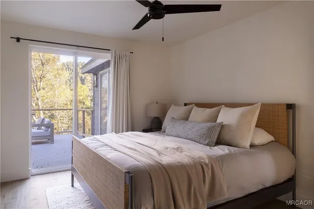 a bedroom with a balcony a bed and a large window