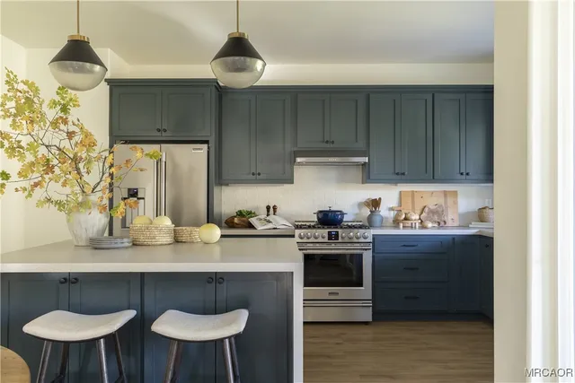 a kitchen with stainless steel appliances a stove a sink and a refrigerator