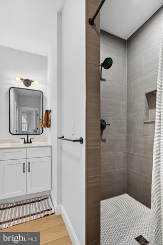 a bathroom with a sink a mirror and shower