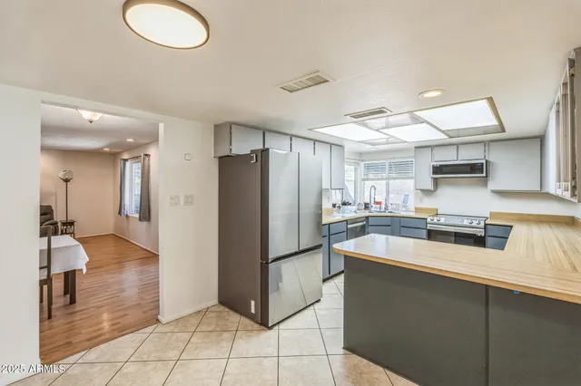 a kitchen with stainless steel appliances granite countertop a refrigerator and a sink