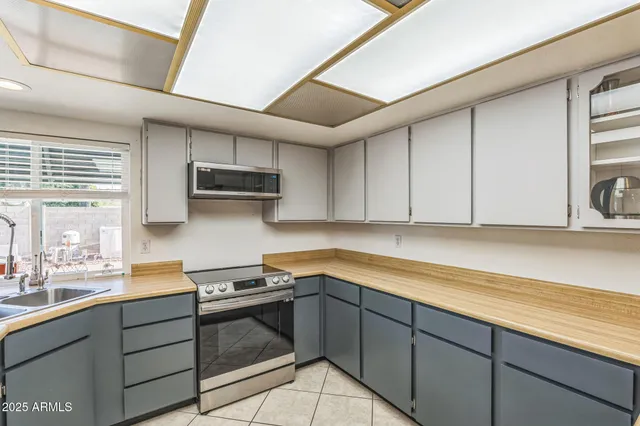 a kitchen with granite countertop a sink stainless steel appliances and cabinets