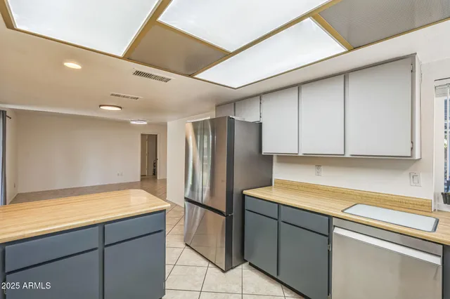 a kitchen with a refrigerator sink and cabinets