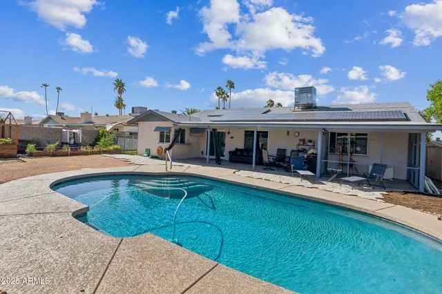 a view of a house with swimming pool and sitting area