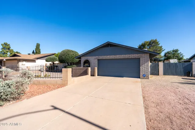 a view of a house with a small yard and wooden fence