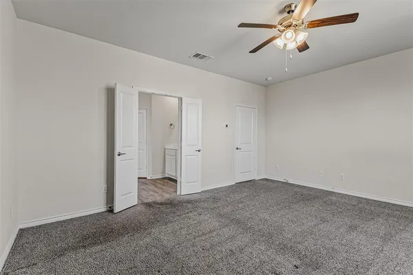 an empty room with closet and a chandelier fan