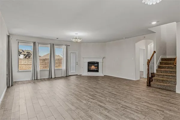 a view of an empty room with a fireplace and a window