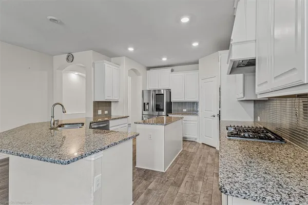 a kitchen with stainless steel appliances granite countertop a sink stove and refrigerator