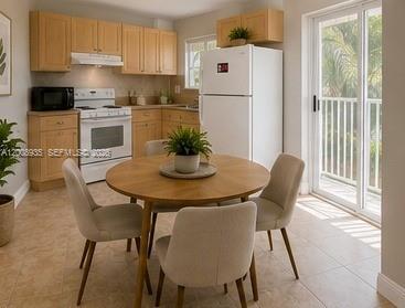 948 Southwest 3rd Street, Unit 205 Miami, FL 33130 - Photo 5 of 11 a kitchen with a dining table chairs and refrigerator