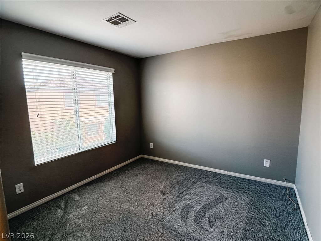 8683 Moreno Mountain Avenue Las Vegas, NV 89178 - Photo 15 of 26 Comfortable carpeting and ample natural light define this inviting sleeping space.