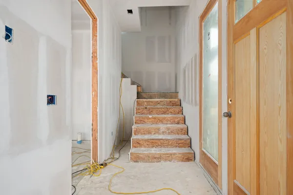 a view of a bedroom with wooden floor and white walls