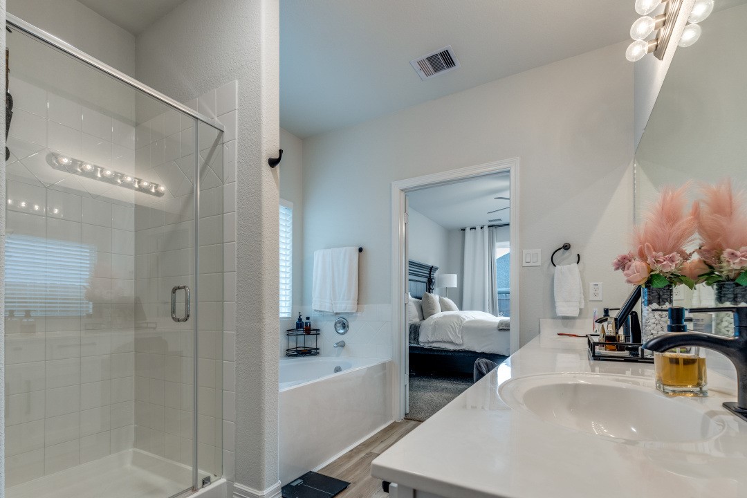 8327 Calico Pennant Way Fulshear, TX 77441 - Photo 22 of 44 a en suite spacious bathroom with a tub shower and mirror