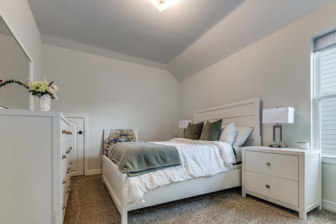 8327 Calico Pennant Way Fulshear, TX 77441 - Photo 32 of 44 a bedroom with a bed and a potted plant