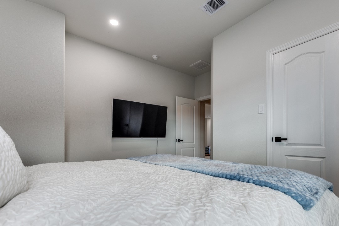 8327 Calico Pennant Way Fulshear, TX 77441 - Photo 35 of 44 a bedroom with a bed and a flat screen tv