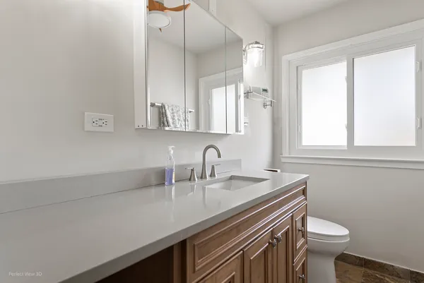 a bathroom with a sink a toilet and a mirror