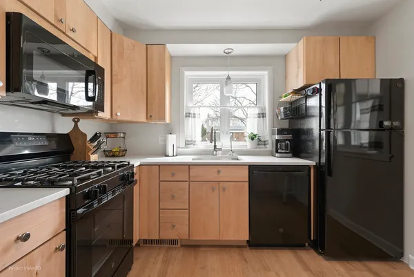 a kitchen with granite countertop a refrigerator stove and sink