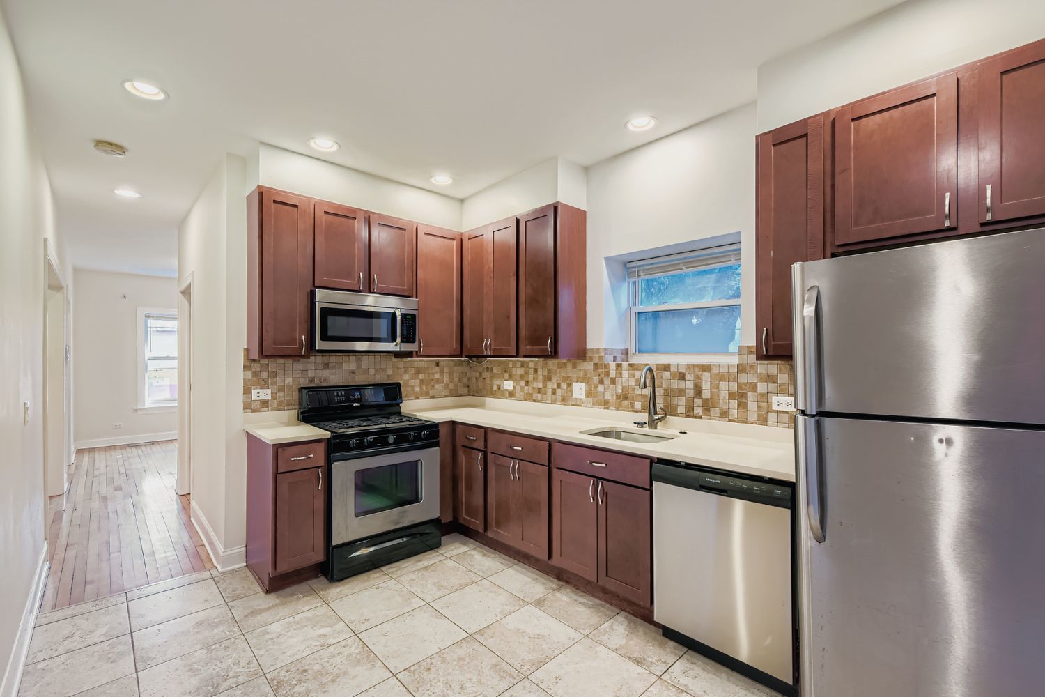 2700 North Artesian Avenue, Unit 1 Chicago, IL 60647 - Photo 4 of 11 a kitchen with stainless steel appliances granite countertop a refrigerator sink and cabinets