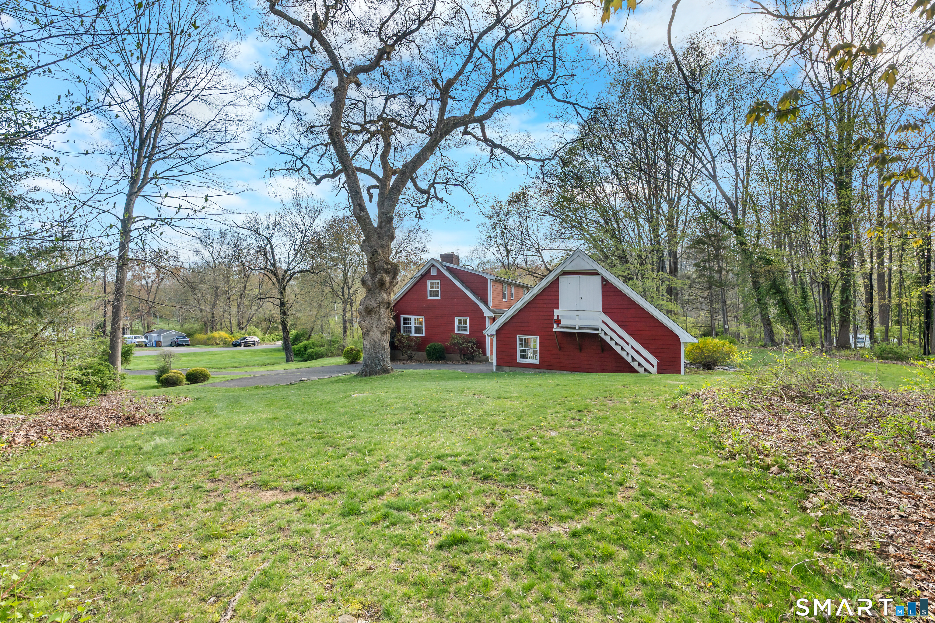 27 Valley Road Shelton, CT 06484 - Photo 25 of 32 a house with tall trees in the background