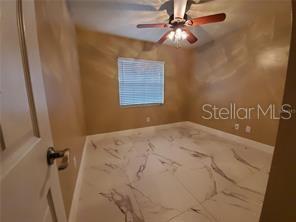 820 Crenshaw Lake Road Lutz, FL 33548 - Photo 14 of 48 a bedroom with a bed and a chandelier