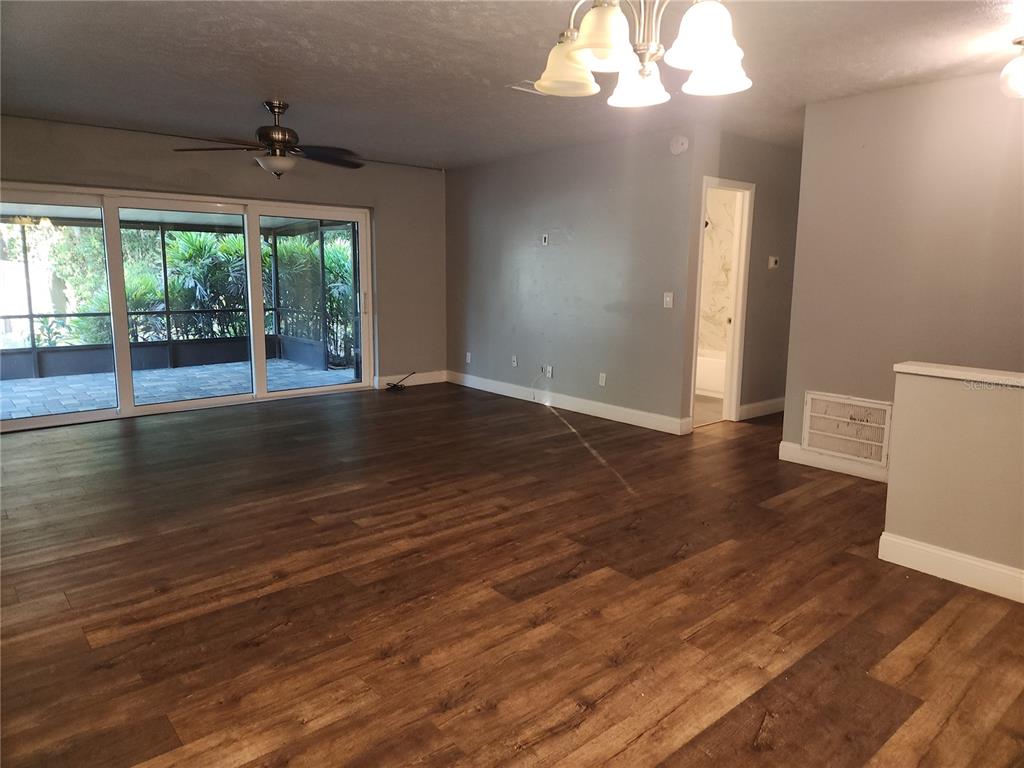 820 Crenshaw Lake Road Lutz, FL 33548 - Photo 30 of 48 a view of an empty room with wooden floor and a window