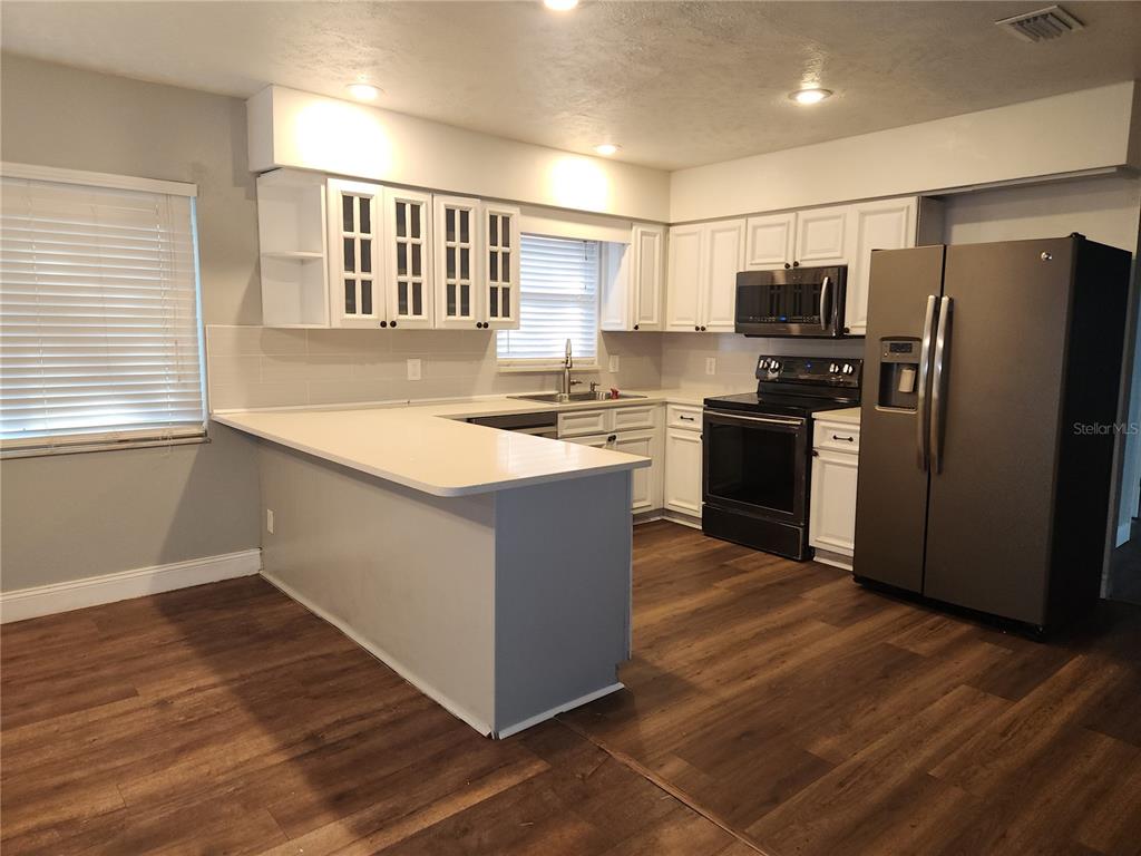 820 Crenshaw Lake Road Lutz, FL 33548 - Photo 6 of 48 a kitchen with stainless steel appliances granite countertop a sink stove and refrigerator