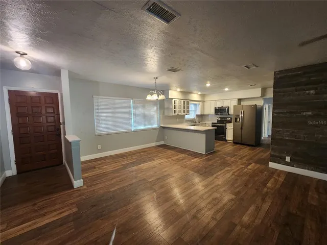 a view of a hallway with entryway wooden floor and front door