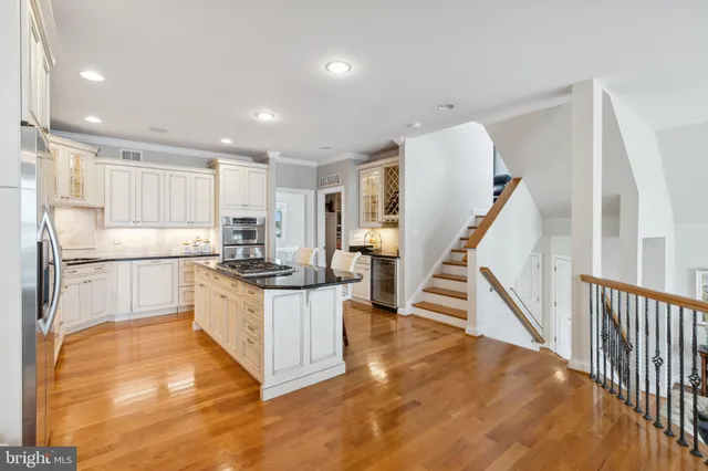 a kitchen with stainless steel appliances granite countertop a stove and white cabinets