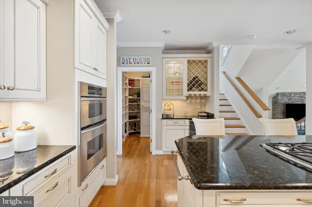 a view of a dining room with furniture a chandelier and large windows