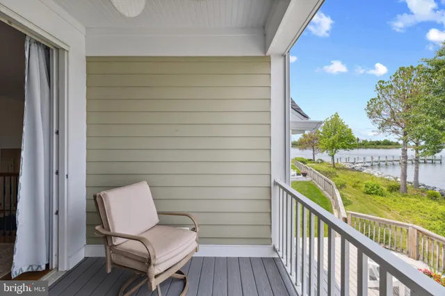 a view of a balcony with two chairs and wooden fence