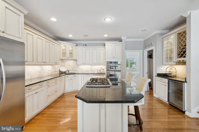 a kitchen with granite countertop kitchen island stainless steel appliances a sink a stove a refrigerator cabinets and a dining table