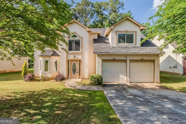 a front view of a house with yard and trees