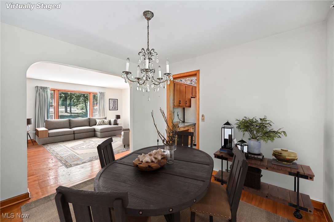 4957 South Raccoon Road Canfield, OH 44406 - Photo 20 of 43 Dining area featuring wood finished floors, a chandelier, and arched walkways