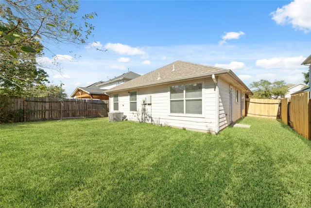 a view of a yard in front of a house with a large tree
